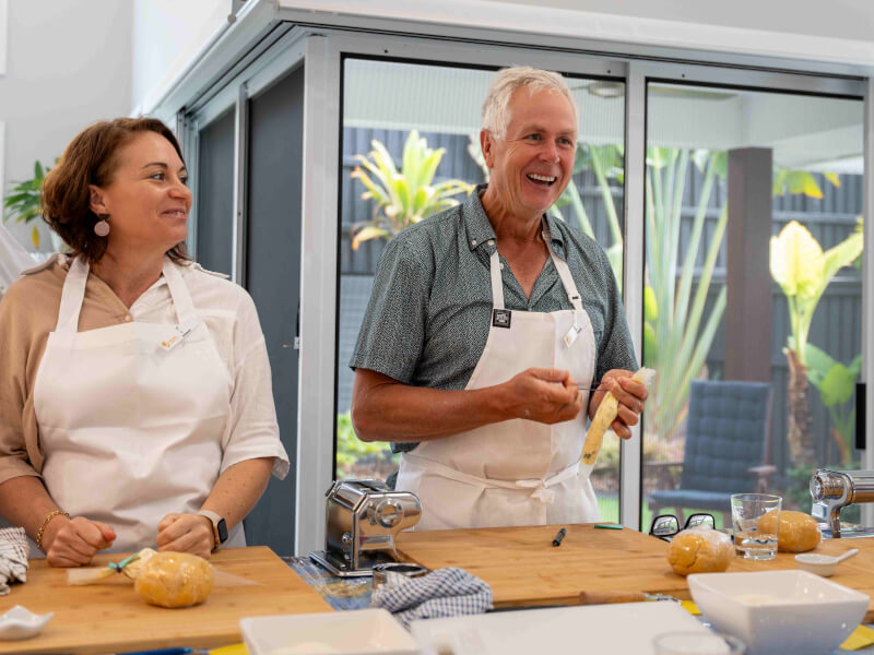 Man and women in a cooking class smiling